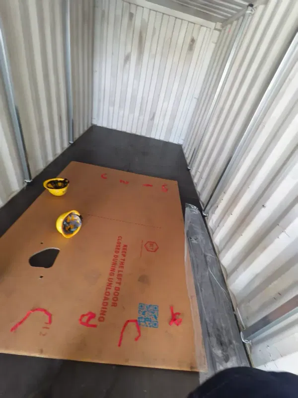 Worker preparing protective cardboard sheets for the container floor before DOTP flexibag installation