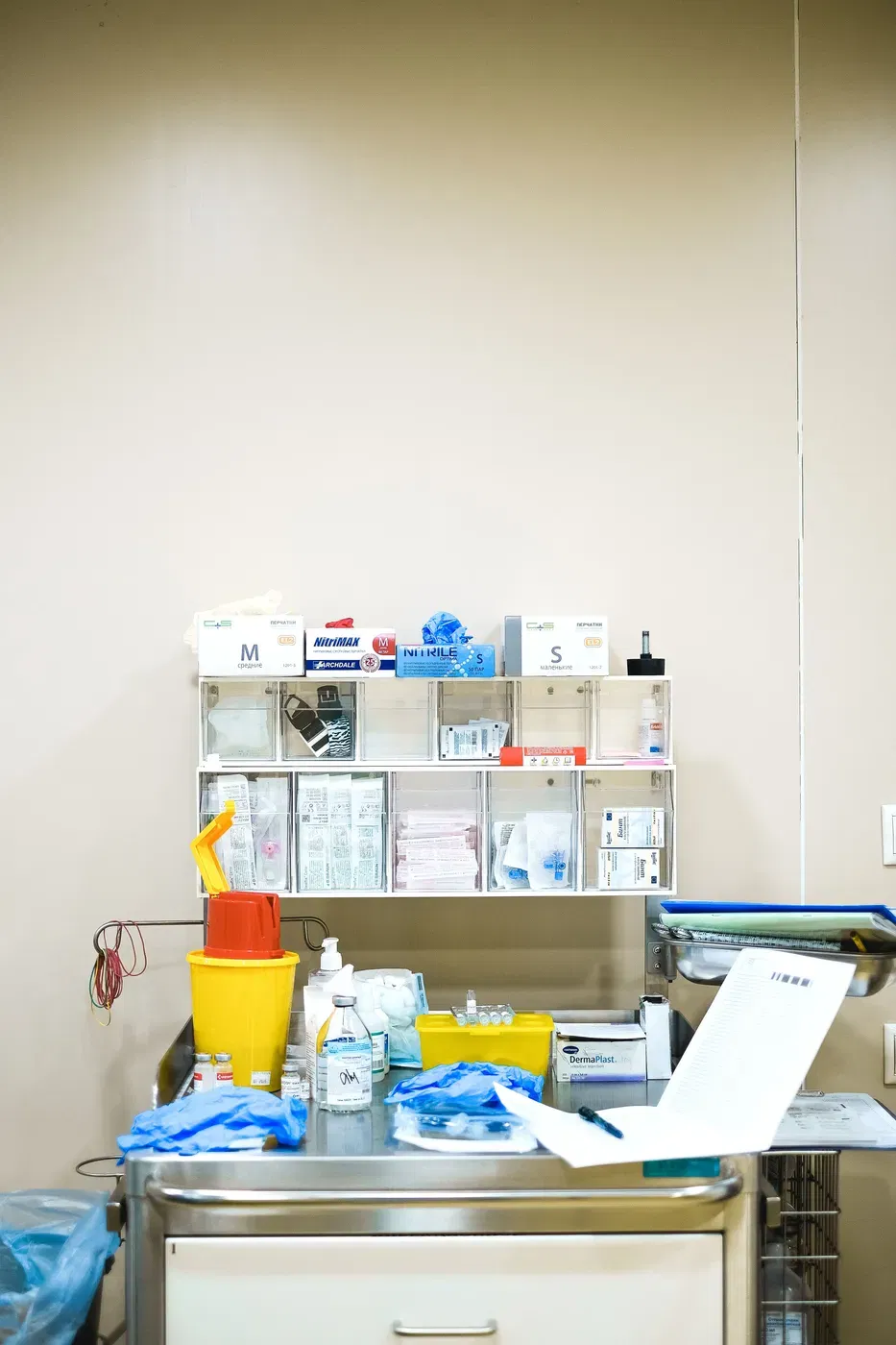 Boxed disposable examination gloves at a dispensing station in a clinical setting